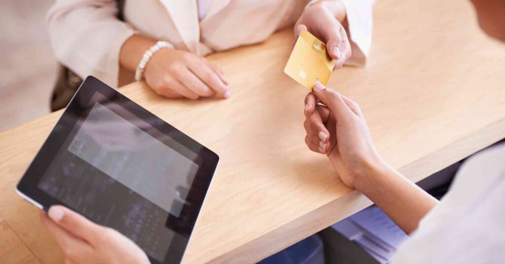 Store associate taking payment and using and iPad to transact