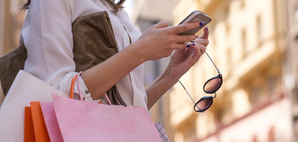 Woman checking her smartphone while shopping