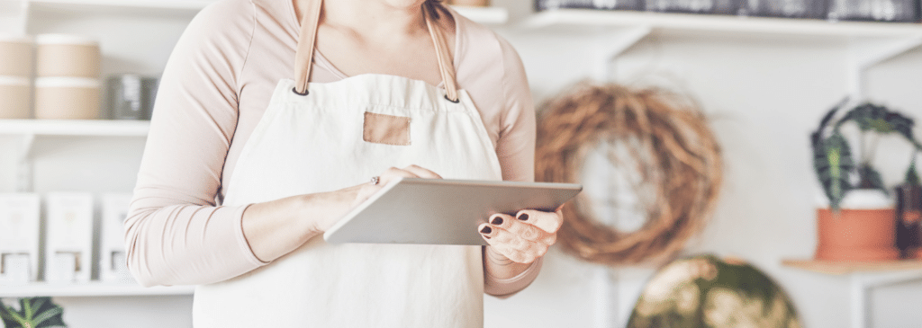 Sales associate in apron looking at iPad