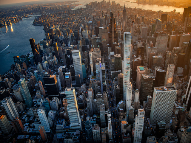 Panoramic aerial view of a dense New York City skyline at sunset, with monumental skyscrapers symbolizing the scale of retail innovation and the industry's focus on the future of the physical store as showcased at NRF 2026.